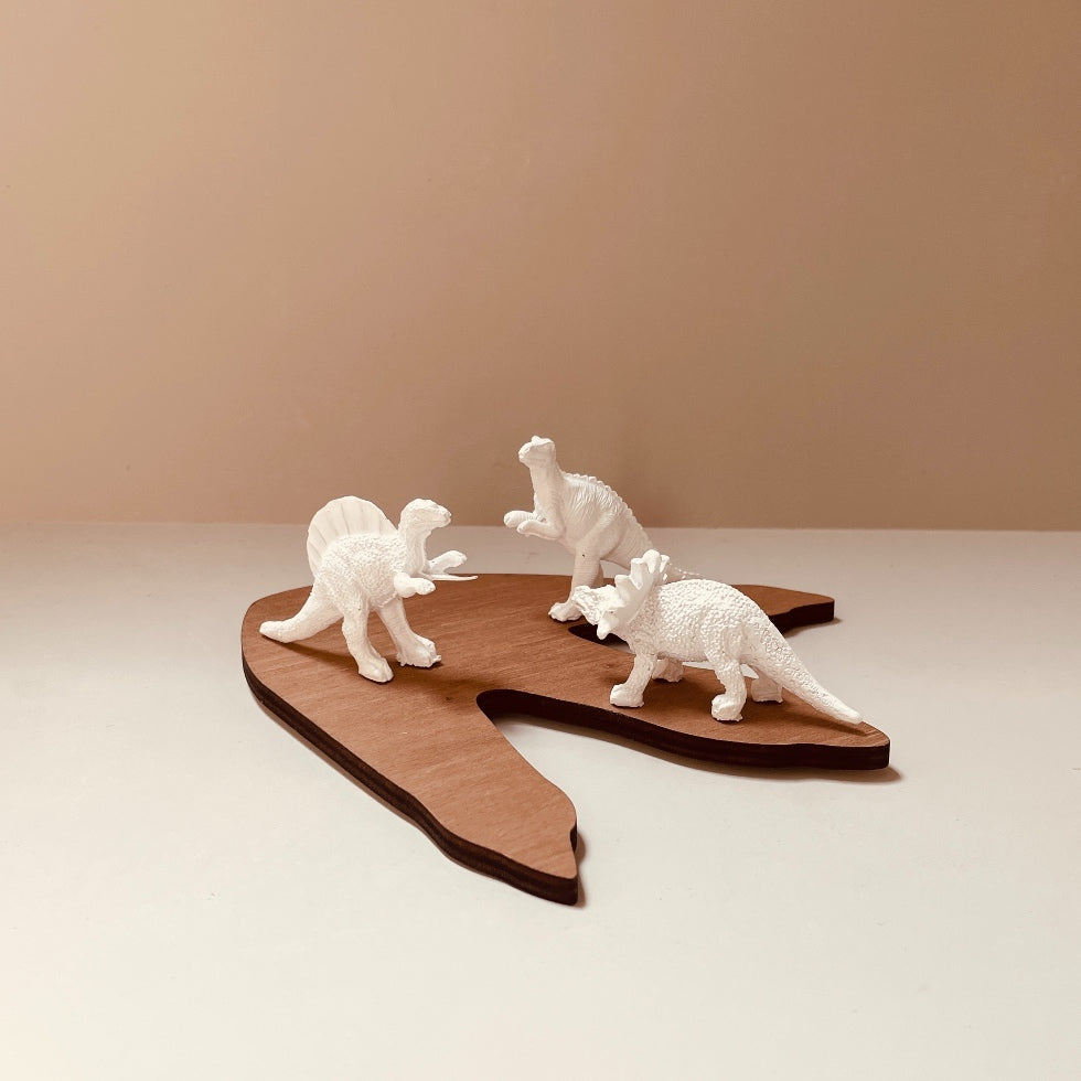 trois- figurines blanches dinosaures-sur-empreinte-bois