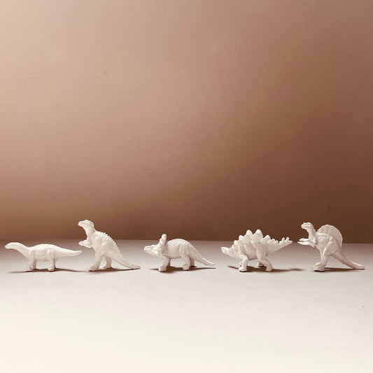 cinq-figurines-dinosaures-blancs-en ligne-fond marron-décorations